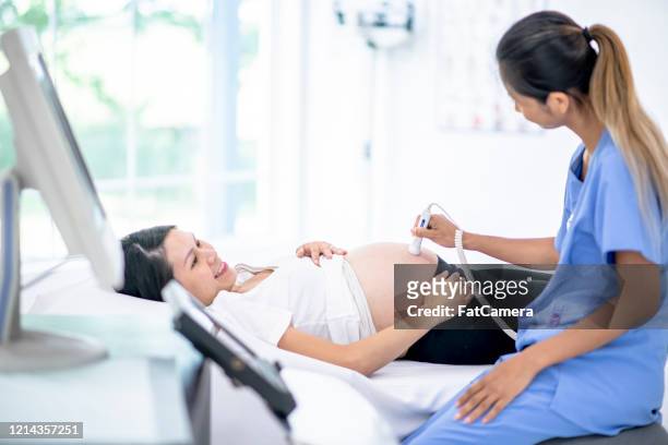 doctor performs a pregnancy ultrasound stock photo - cambodian ethnicity stock pictures, royalty-free photos & images