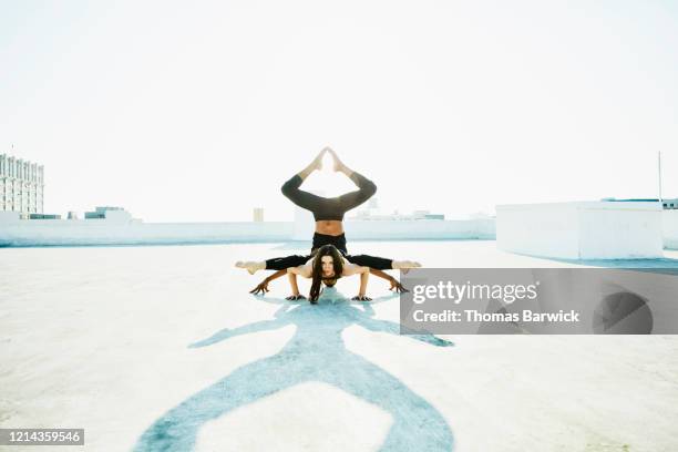 dance partners balancing together while performing on rooftop - friendly match stockfoto's en -beelden