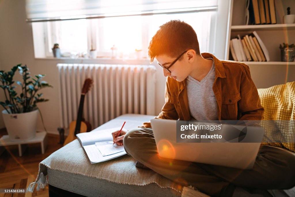 Teenage boy attending to online school class