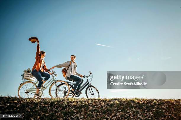 paar entspannen auf der sonne mit demfahrrad in der natur - happy sprong two persons sun stock-fotos und bilder