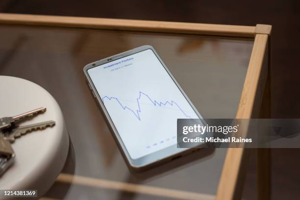 smartphone with financial app showing declining stock portfolio - stillleben stock-fotos und bilder