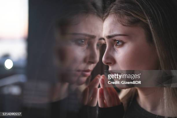 mujer infeliz llorando en la ventana - rejection fotografías e imágenes de stock