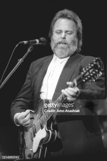 Singer, songwriter & guitarist Carl Wilson is shown performing on stage during a live concert appearance with The Beach Boys on June 1, 1991.