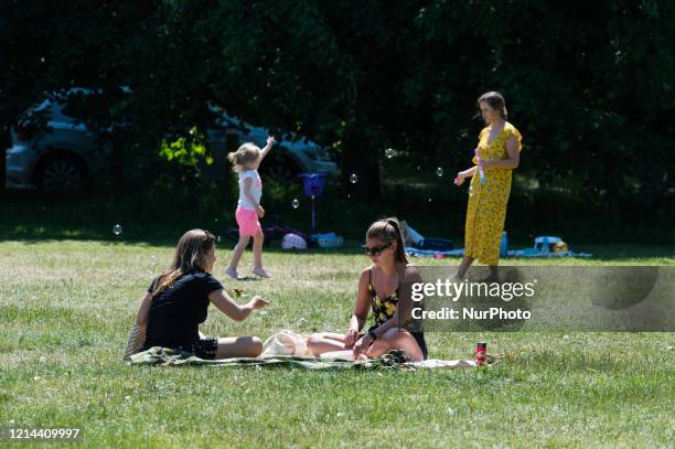 People enjoy the sunny weather in Clapham Common in south-west London as high temperatures continue ahead of the Bank Holiday weekend on 21 May, 2020...