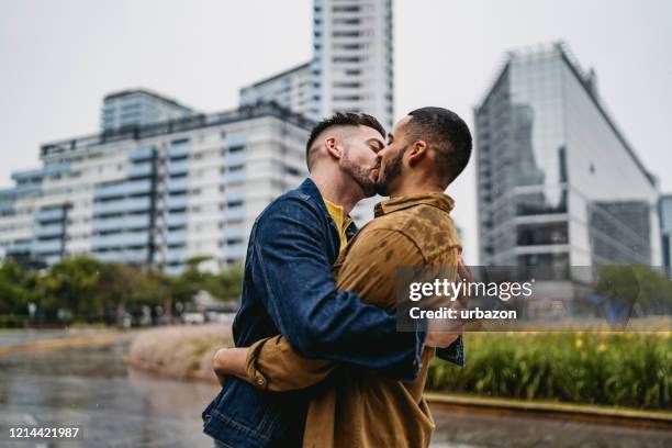 homopaar in liefde - rain kiss stockfoto's en -beelden