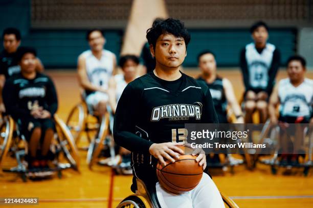 Portrait of a wheelchair basketball player with his team behind him