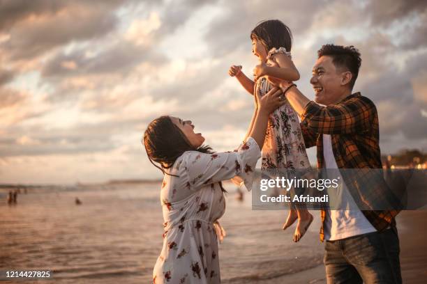 happy family playing at the beach - etnia indonésia imagens e fotografias de stock