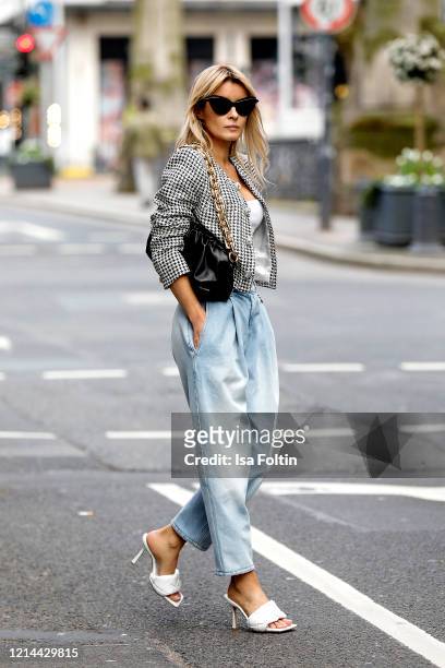 Influencer Gitta Banko, wearing a wide cut Jeans by Magda Butrym, a short jacket with Houndstooth pattern by Alessandra Rich, a black chain pouch bag...
