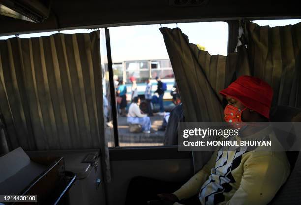 Commuter wears a face mask as a preventive measure against the spread of the COVID-19 coronavirus while sitting in a bus in Gaborone on May 21, 2020....