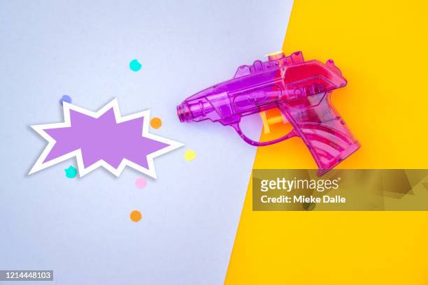 waterpistool op een gekleurde achtergrond - gekleurde achtergrond - fotografias e filmes do acervo