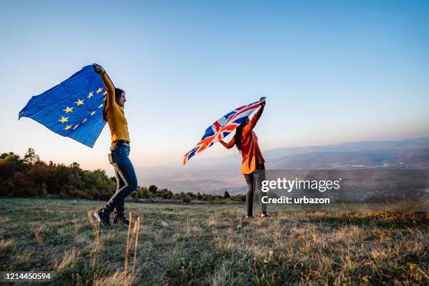 zwei multiethnische frauen mit euer und britischer flagge - brexit flags stock-fotos und bilder