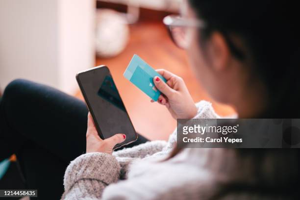 woman using smart phone and credit card for shopping online - credit card debt stockfoto's en -beelden