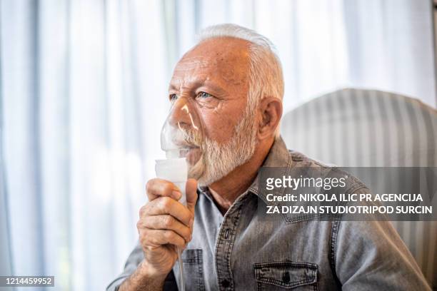 senior inhalation therapy in progress during pandemic covid-19 . corona virus. - emphysema stock pictures, royalty-free photos & images