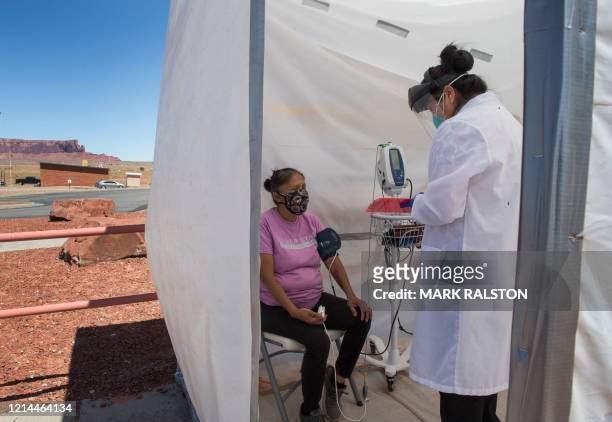 Nurse checks vitals from a Navajo Indian woman complaining of virus symptoms, at a COVID-19 testing center at the Navajo Nation town of Monument...