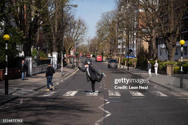 London, United Kingdom A member of the public wearing a protective mask poses as he walks on the iconic Abbey Road pedestrian crossing on March 24,...