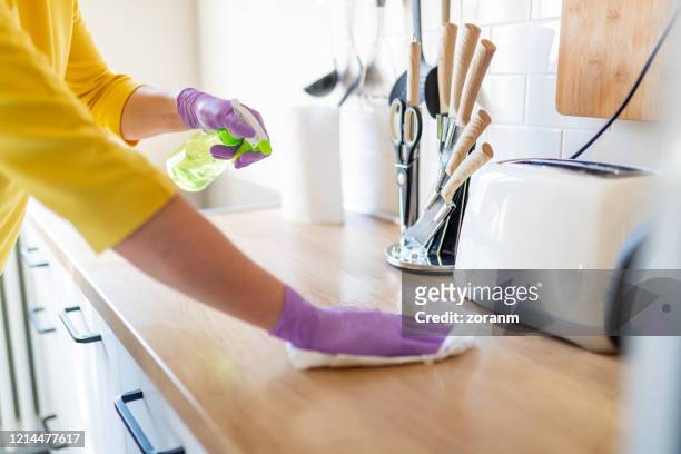 hands in gloves disinfecting kitchen counter - rubbing stock pictures, royalty-free photos & images