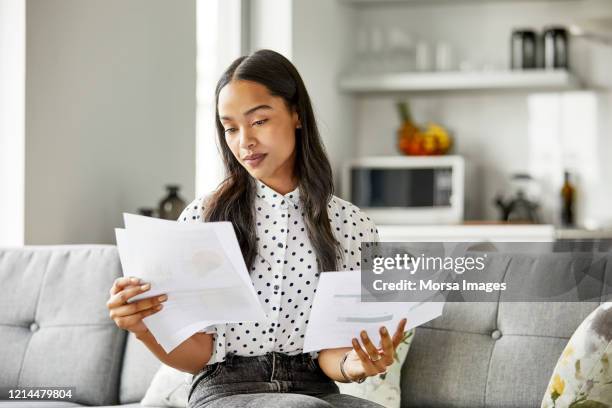 femme analysant des documents financiers à la maison - brief photos et images de collection