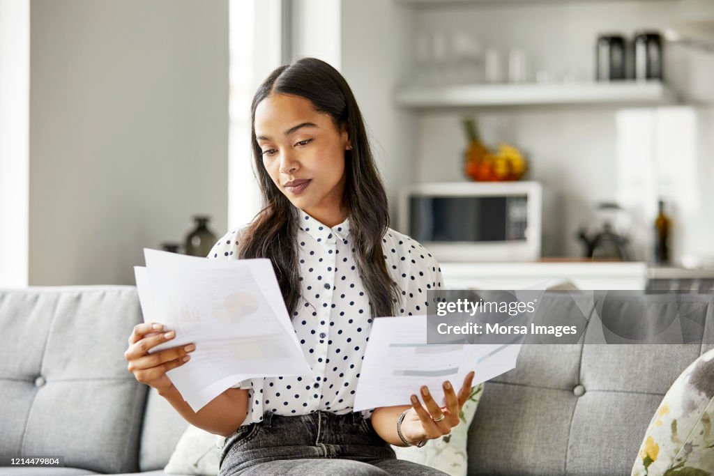 Woman analyzing financial documents at home