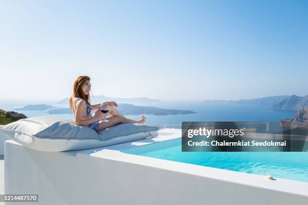 a beautiful woman is enjoying her time in santorini, greece - luxury cruise relaxing stock pictures, royalty-free photos & images