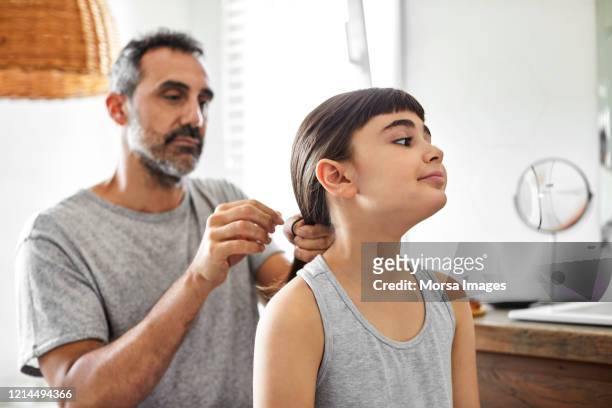 Gay man is tying daughter's hair in bathroom