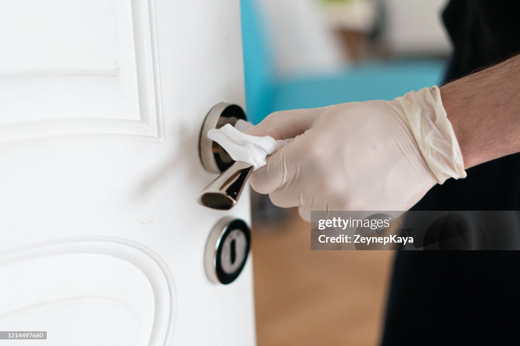 Wiping down surfaces with rubber gloves.