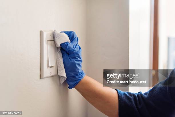 hand with glove wiping light switch. - light switch stock pictures, royalty-free photos & images