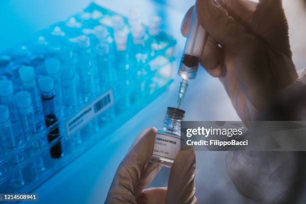 doctor preparing the coronavirus covid-19 vaccine - covid 19 travel stock pictures, royalty-free photos & images