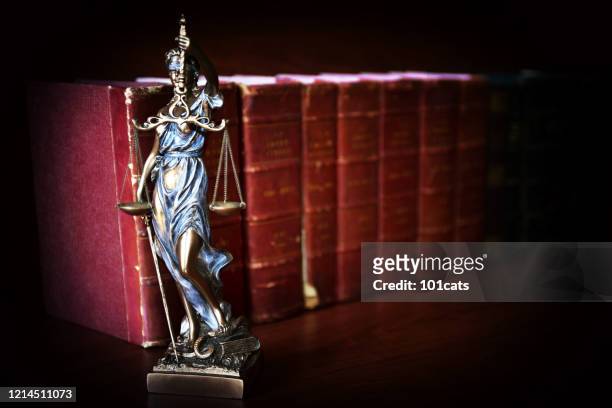 statua della giustizia davanti ai libri di legge - temi - crimine foto e immagini stock