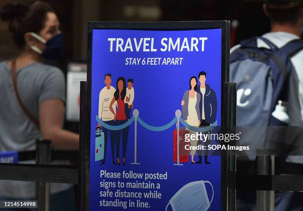 Sign reminding passengers to stay 6 feet apart is seen at a screening checkpoint at Orlando International Airport. The Transportation Security...