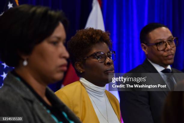 Dr. LaQuandra Nesbitt, C, director of the District of Columbia Department of Health, joins DC mayor Muriel Bowser, L, and Lewis D. Ferebee, R,...
