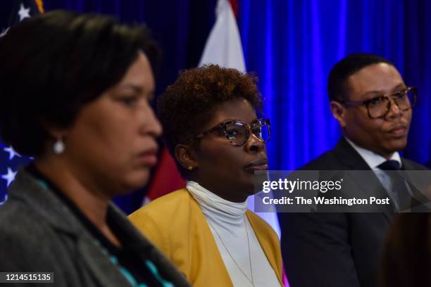 Dr. LaQuandra Nesbitt, C, director of the District of Columbia Department of Health, joins DC mayor Muriel Bowser, L, and Lewis D. Ferebee, R,...
