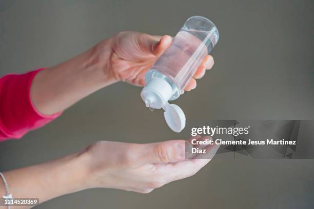 female doctor disinfecting covid virus hands with disinfecting gel - medico stock pictures, royalty-free photos & images