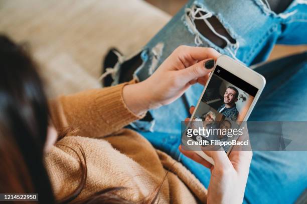 junge frau verbindet sich mit ihrer familie während der quarantäne - photo call stock-fotos und bilder