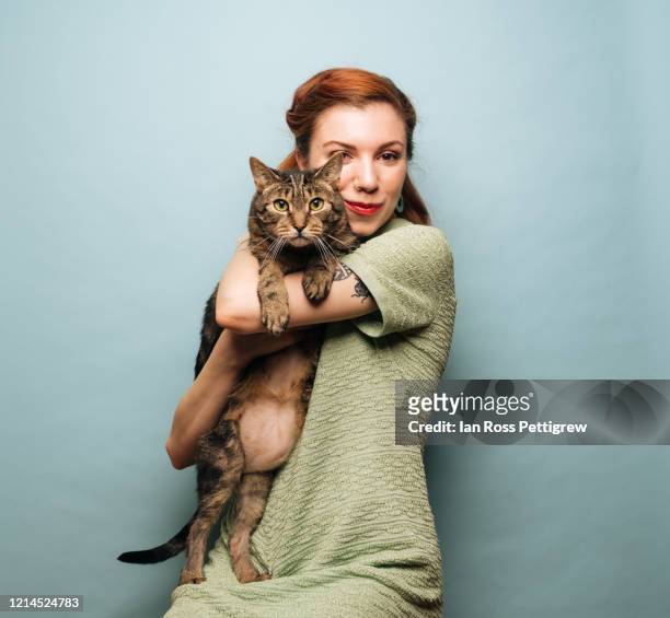 beautiful young woman holding cat - cat portrait stock-fotos und bilder