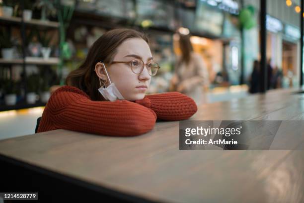 teenage girl wearing protective face mask in a public place - coronavirus quarantine stock pictures, royalty-free photos & images