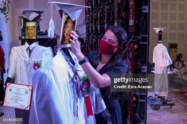 Teacher loads a picture of a graduating student on a tablet attached to a robot during a "cyber graduation" ceremony at a school on May 22, 2020 in...