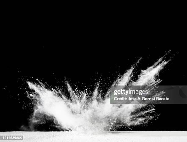 explosion by an impact of a cloud of particles of powder of white color on a black background. - colourful studio shots stock-fotos und bilder