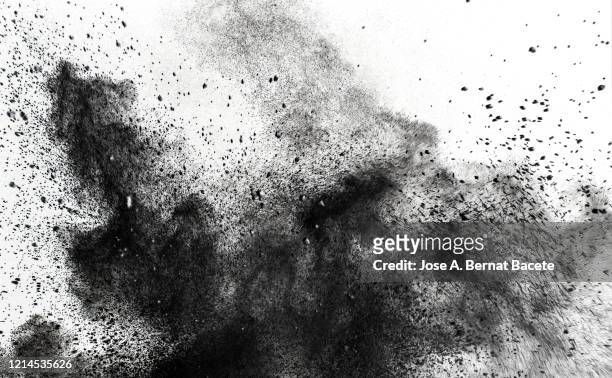 explosion by an impact of a cloud of particles of powder and smoke of black color on a white background. - shooting a weapon stock pictures, royalty-free photos & images