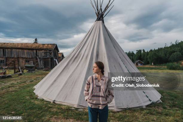 woman standing near teepee in lapland - tipi stock pictures, royalty-free photos & images