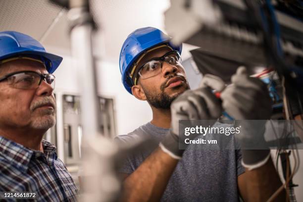 elektriker arbeiten an einem sicherungskasten - safety glasses stock-fotos und bilder