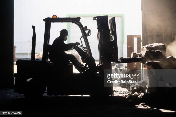 employee using forklift in factory - dirty construction worker stock pictures, royalty-free photos & images