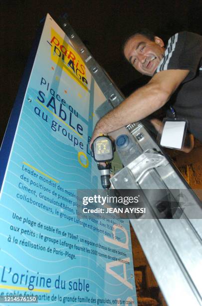 Un technicien installe, le 19 juillet 2004 dans la nuit, un panneau d'information lors de l'installation sur les quais de la Seine à Paris, les...