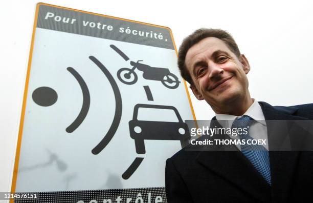 Le ministre de l'Intérieur Nicolas Sarkozy pose devant un panneau indiquant aux automobilistes un contrôle radar, le 27 octobre 2003 le long de la...