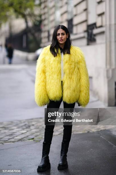 Gilda Ambrosio wears a yellow fluffy faux fur coat, black pants, black leather boots, outside Alessandra Rich, during Paris Fashion Week - Womenswear...