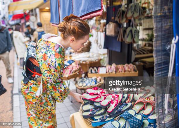「ゾリ」日本のサンダルショップで着物の買い物をしている若い白人女性 - 下駄 ストックフォトと画像