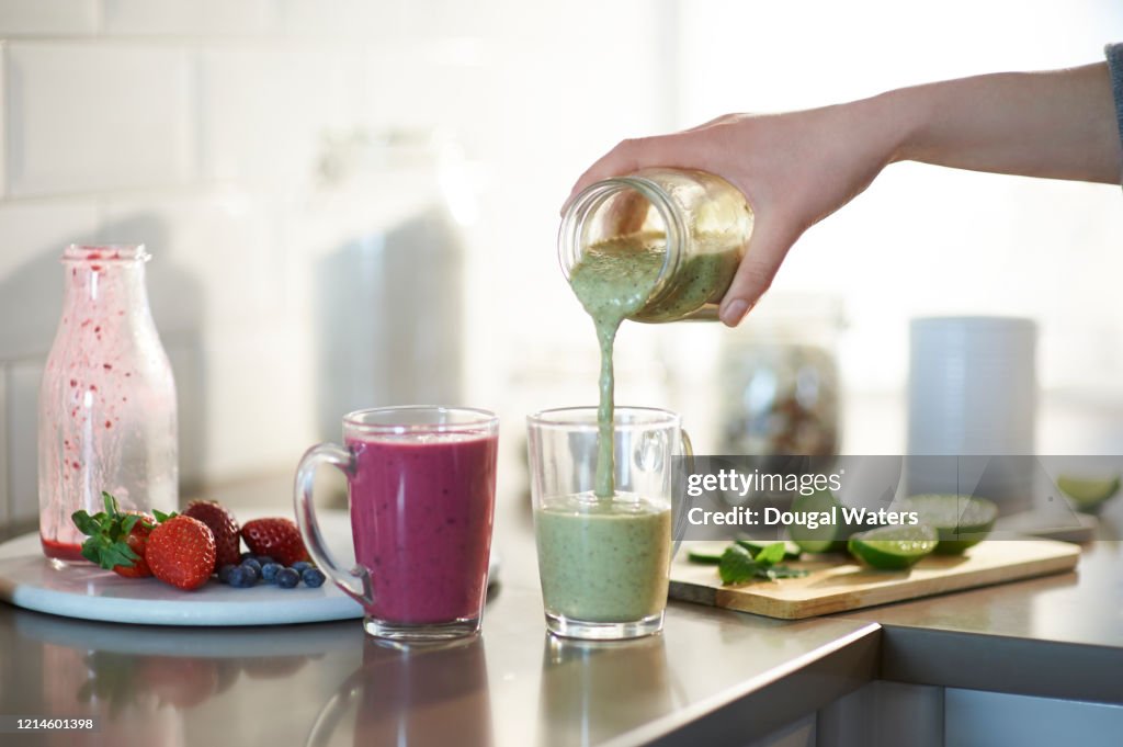 Freshly made smoothies poured into glasses.