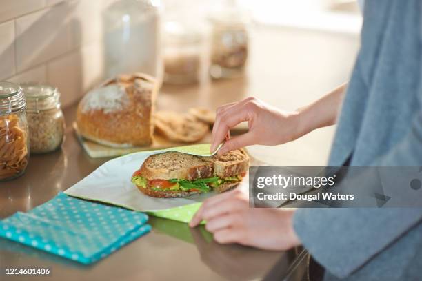 woman wrapping vegan sandwich in plastic free reusable food wrap. - sliced bread bildbanksfoton och bilder