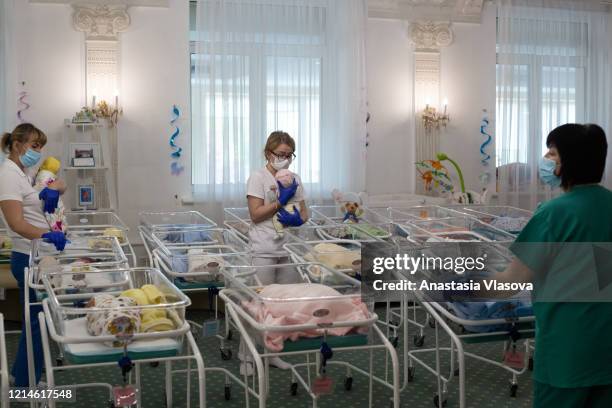 Nurses take care of the infants in the Venice Hotel on May 22, 2020 in Kyiv, Ukraine. Dozens of babies, born to surrogate mothers in Ukraine, are...