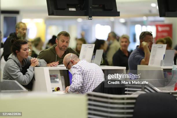 Passengers queue at a check in desk at Sydney International Airport on March 25, 2020 in Sydney, Australia. Prime Minister Scott Morrison has...