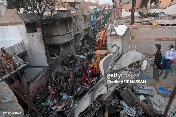 Security personnel search for victims in the wreckage of a Pakistan International Airlines aircraft after it crashed in a residential area in Karachi...